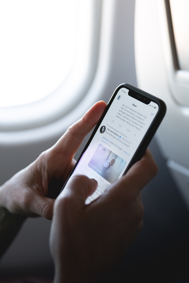 Quelqu'un qui regarde son fil Twitter dans un avion.