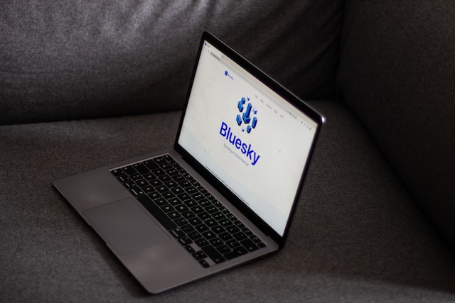 A picture of a laptop displaying Bluesky’s website homepage.